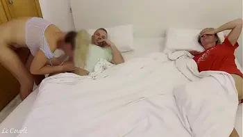 Girlfriend sneaks into swinger couple bedroom to fuck husband