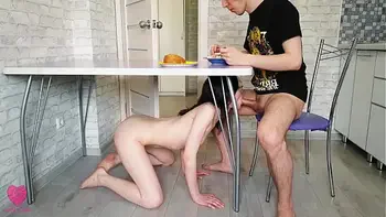 The girl crawled under the table and sucked his dick to satisfy her hunger while the guy was eating
