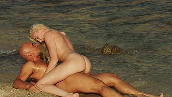 A girl with big boobs is having fun on the beach with her boyfriend.